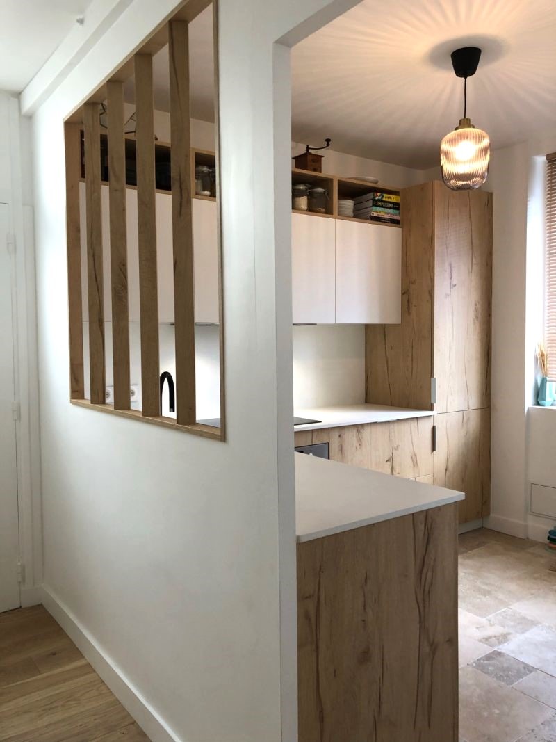 Cuisine italienne Armony Cucine moderne avec façades blanches laquées, gorges noires, meubles hauts en bois et plan de travail en céramique noire à Sucé-sur-Erdre près de Nantes, réalisée par Cuisines de l’Erdre.