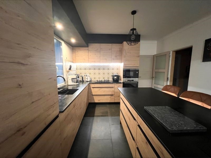 Cuisine contemporaine signée Armony Cucine avec finitions en bois chêne et granit noir, réalisée sur-mesure à Grandchamps-des-Fontaines près de Nantes
