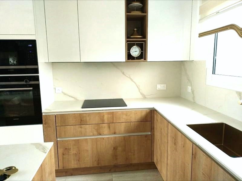 Îlot central en finition bois et céramique Calacatta Oro, dans une cuisine Armony Cucine installée à Ancenis
