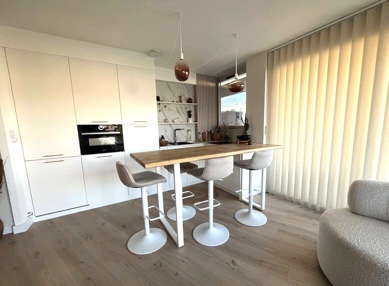 Plan de travail effet marbre beige avec crédence assortie dans une cuisine ARMONY CUCINE à La Baule