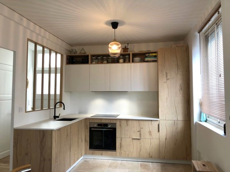 Cuisine italienne Armony Cucine moderne avec façades blanches laquées, gorges noires, meubles hauts en bois et plan de travail en céramique noire à Sucé-sur-Erdre près de Nantes, réalisée par Cuisines de l’Erdre.