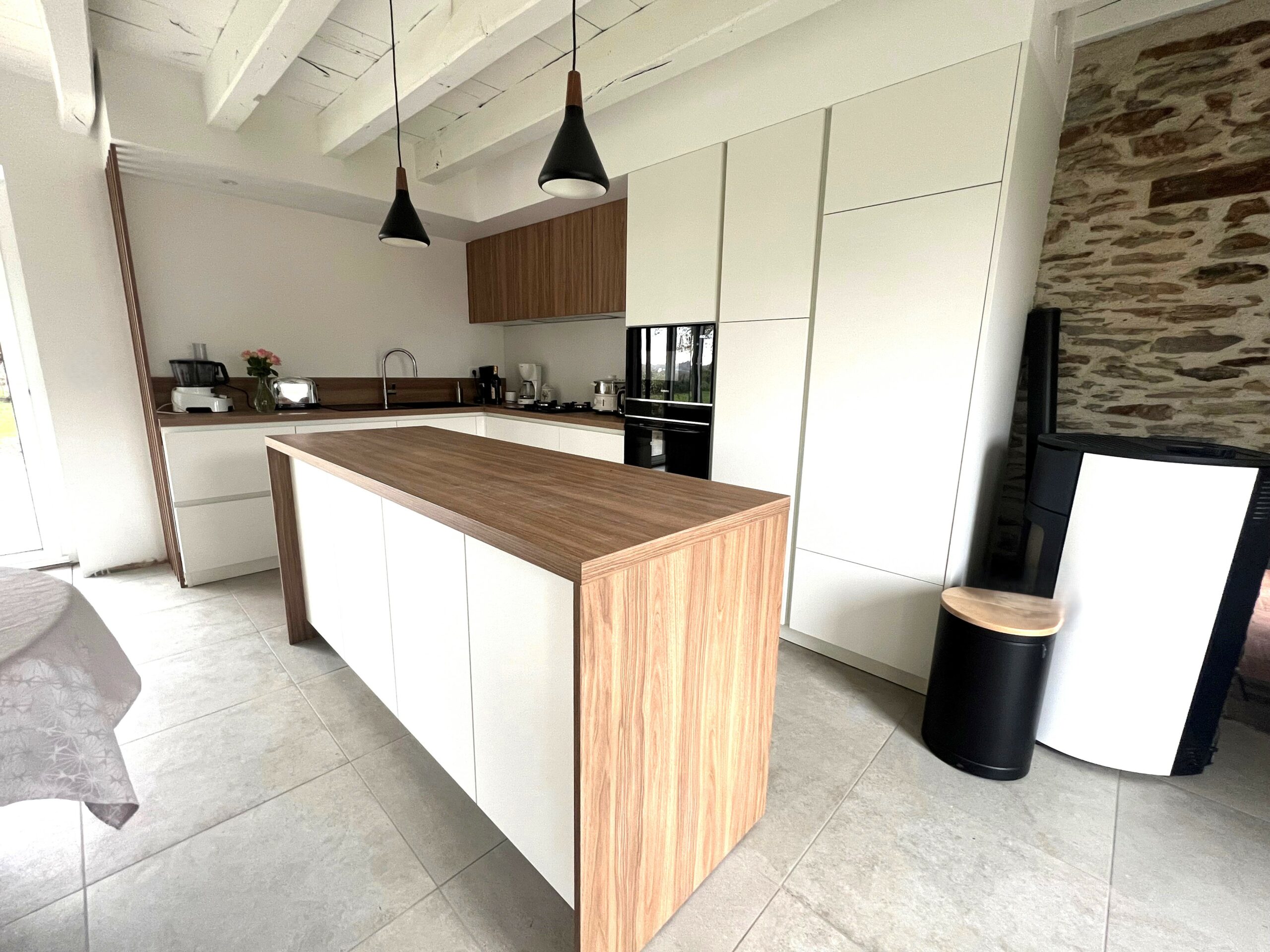 Cuisine haut de gamme Armony Cucine avec plan de travail en bois et claustrat vertical, réalisée à Sucé-sur-Erdre par Cuisines de l’Erdre