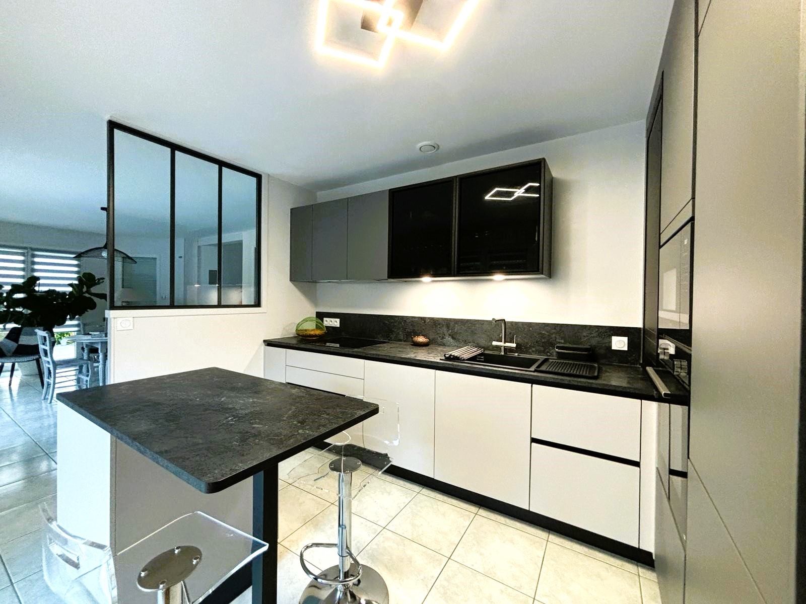 Cuisine sur mesure Armony Cucine à Sucé-sur-Erdre, avec meubles en laque blanche mate et gorges noires.