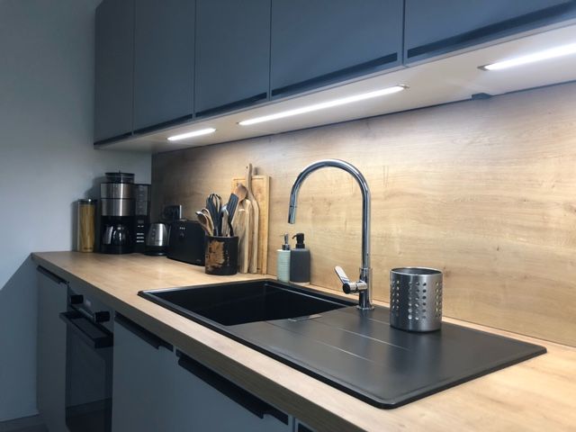 Cuisine haut de gamme Armony Cucine à Rezé avec façades blanches mates et poignées noires intégrées