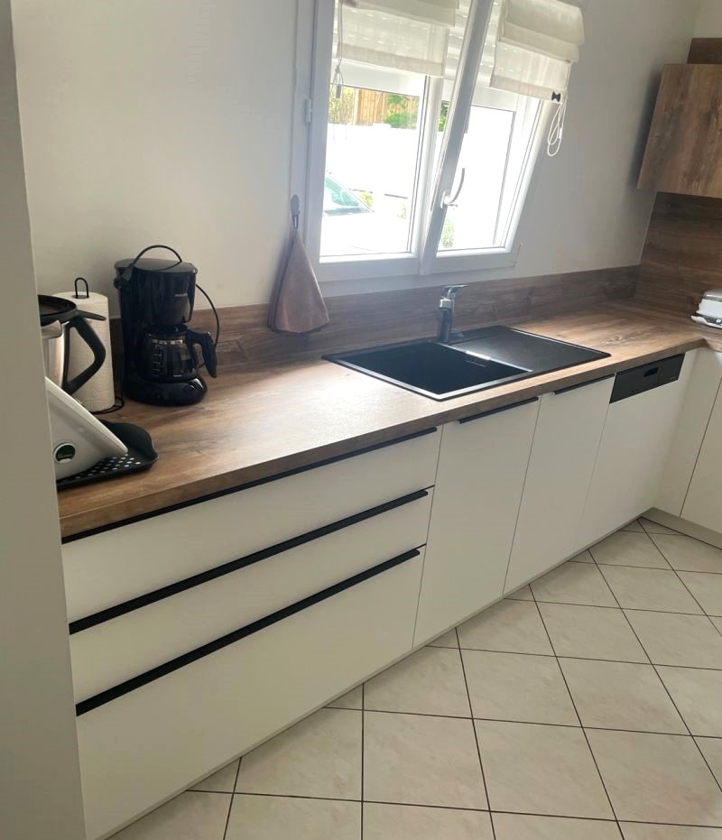 Détails du plan de travail en bois chêne dans une cuisine sur mesure Armony à Orvault, installée par Cuisines de l’Erdre.
