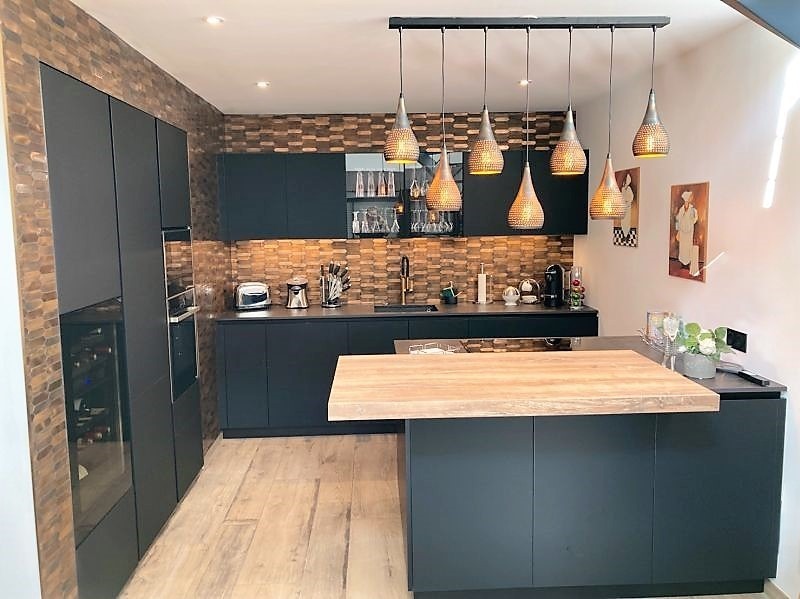 Cuisine aménagée haut de gamme ARMONY CUCINE installée à Carquefou près de Nantes avec façades noir mat et plan de travail Dekton Laurent.