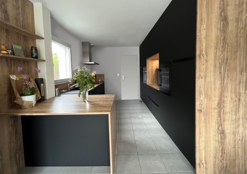Cuisine haut de gamme ARMONY CUCINE à La Chapelle-sur-Erdre avec façades laquées noir et plan de travail bois
