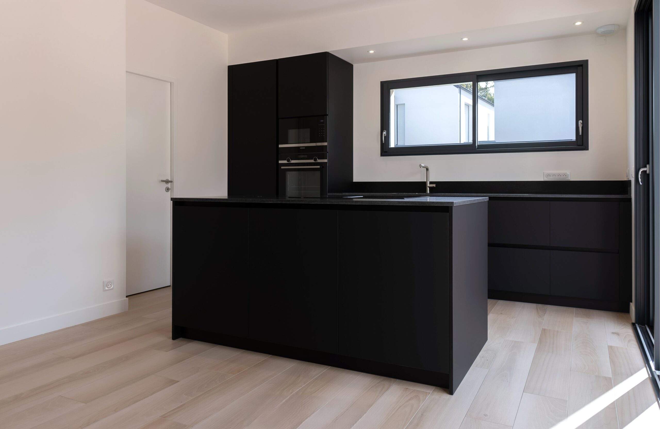 Plan de travail en granit noir Z posé par Anjou Marbre dans une cuisine contemporaine à Orvault