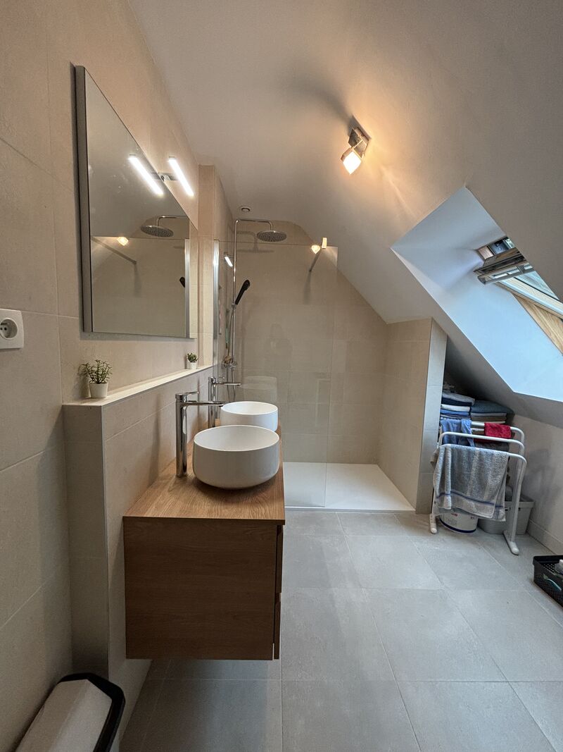 Salle de bain haut de gamme à La Chapelle-sur-Erdre avec meuble suspendu en bois Kios et douche à l'italienne avec carrelage travertin.