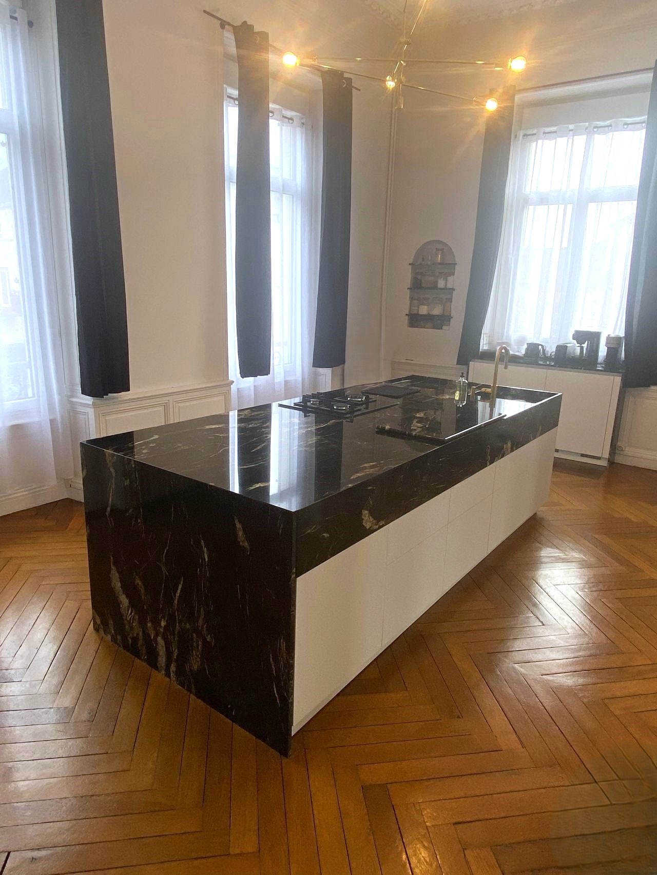 Îlot central contemporain en granit noir veiné dans une cuisine aménagée en Loire-Atlantique