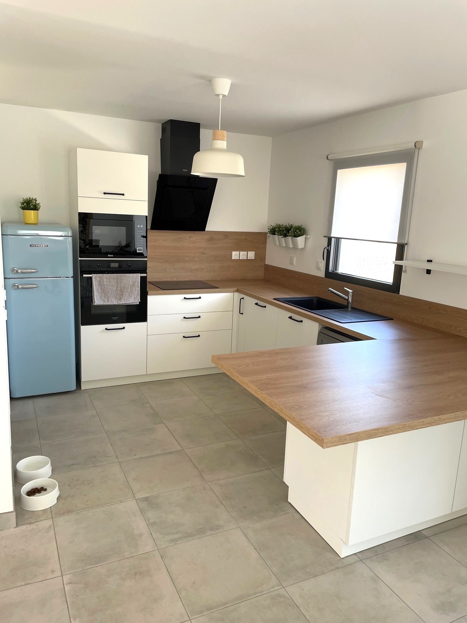 Coin repas avec retour de plan de travail et rangement sur mesure dans une cuisine à Couëron