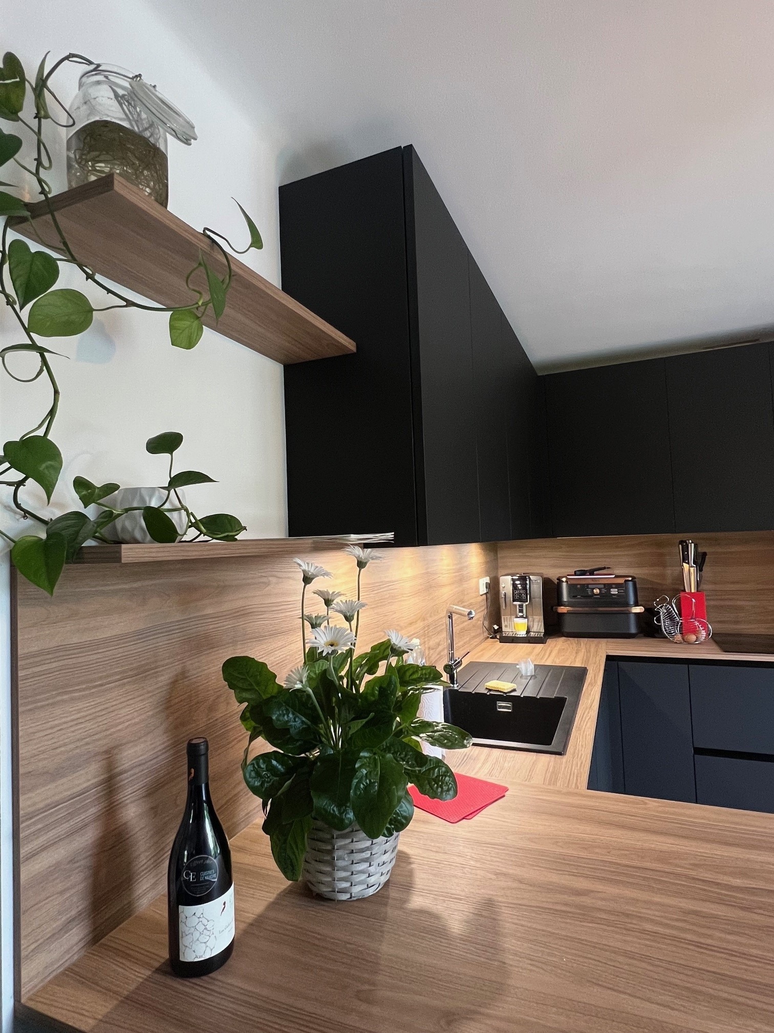 Plan de travail en débord avec coin bar et rangements sur mesure près de Nantes.