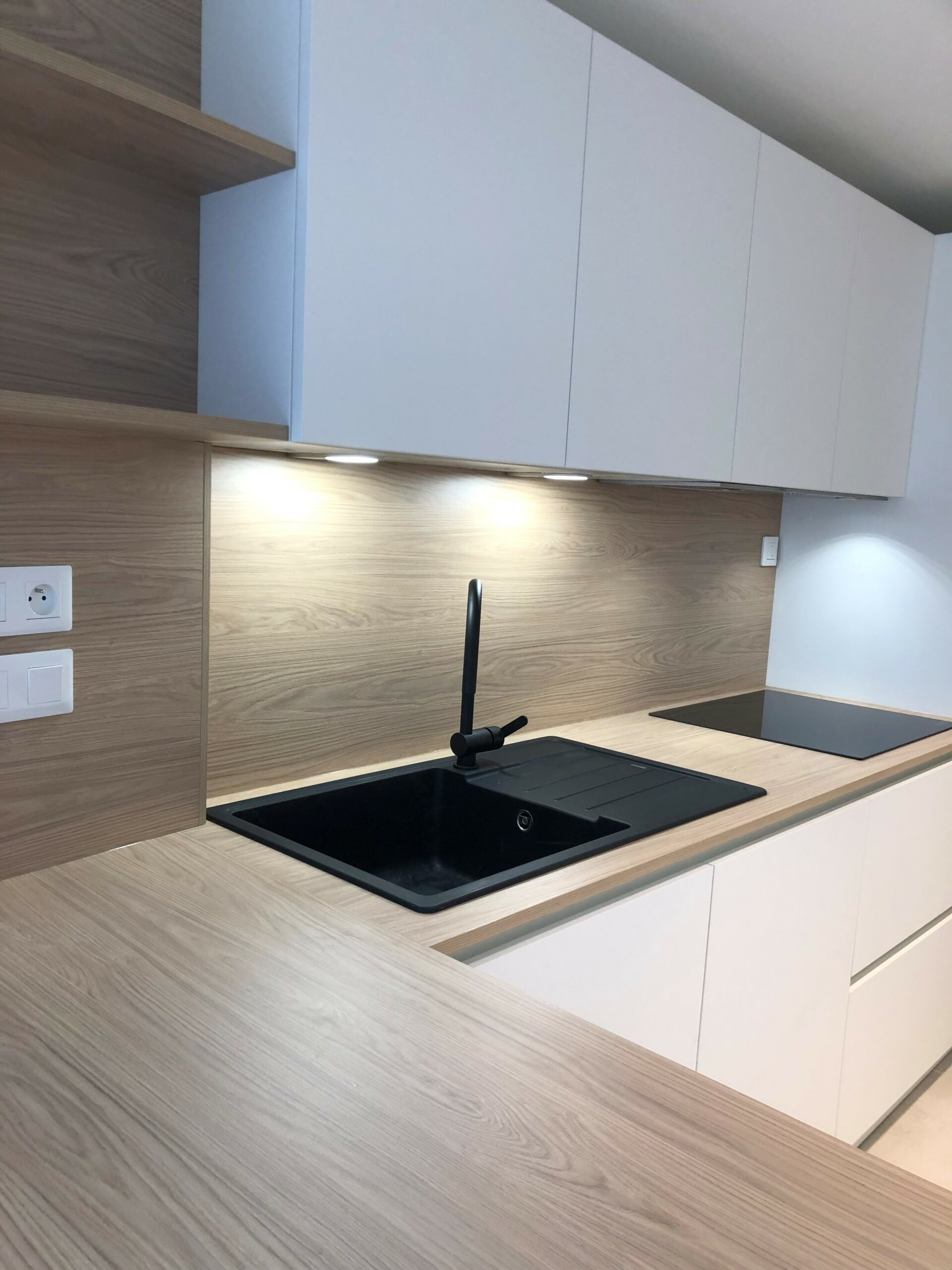 Linéaire de cuisine équipée avec plaque de cuisson et hotte intégrée dans le meuble haut à Sucé-sur-Erdre.