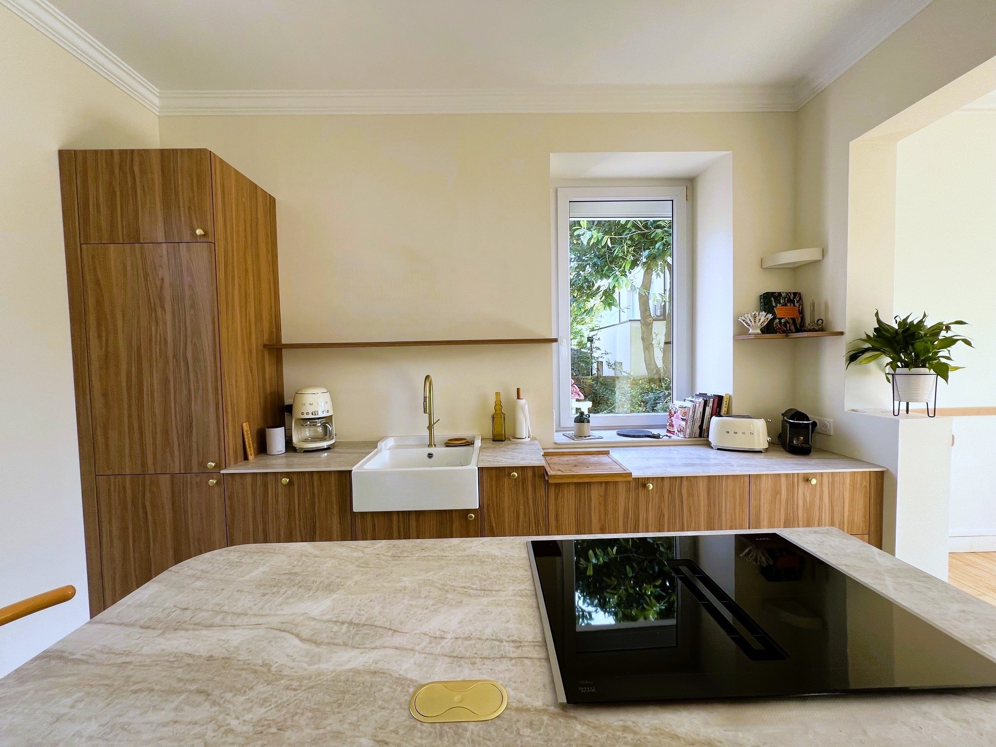 Évier timbre en céramique blanche et mitigeur en laiton doré par Cuisines de l’Erdre.