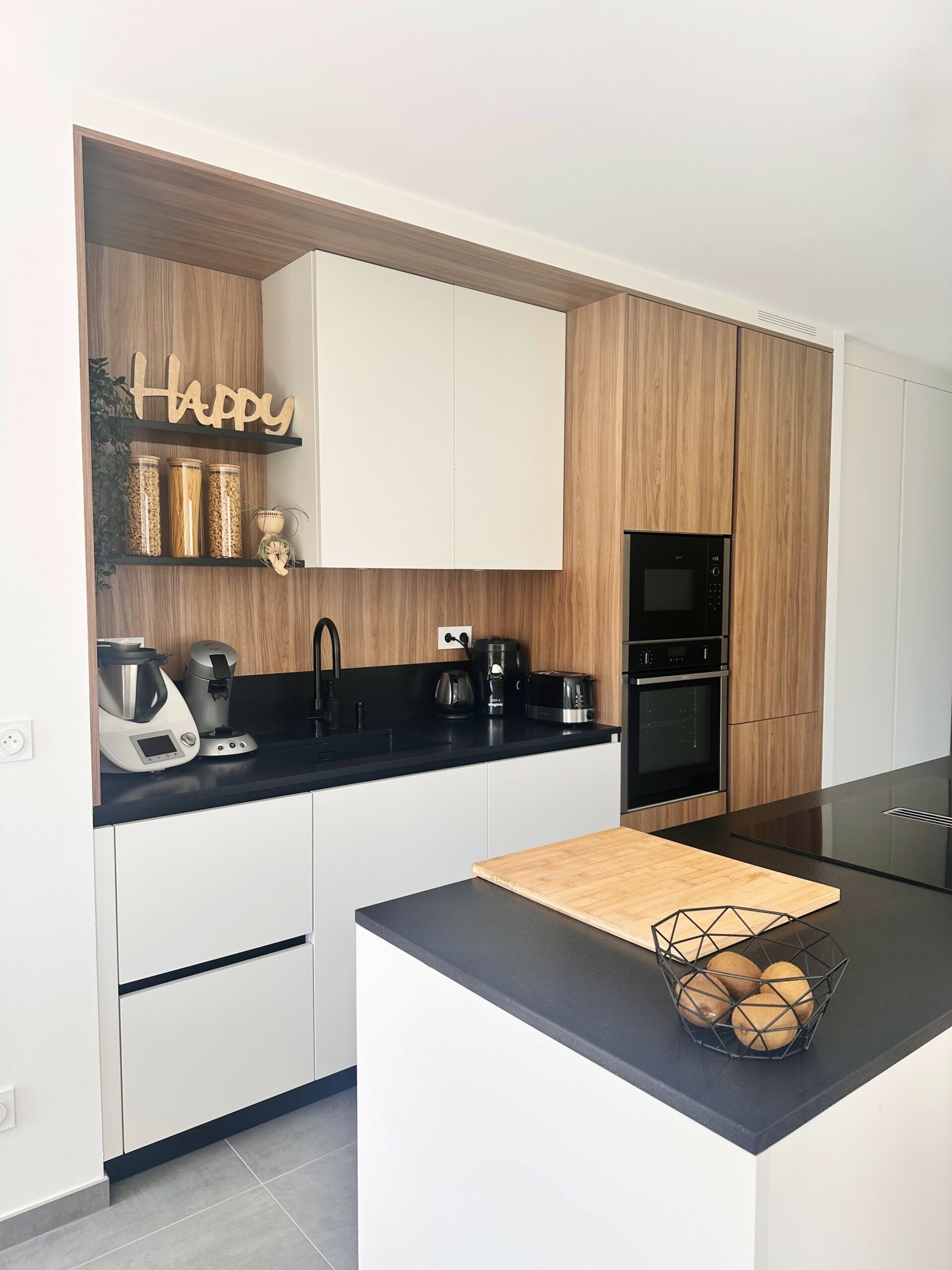 Cuisine contemporaine blanc mat et bois avec plan de travail en granit noir du Zimbabwe à Sucé-sur-Erdre.