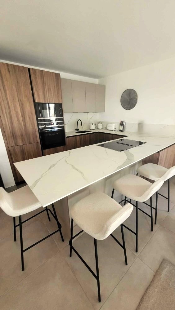 Cuisine contemporaine Armony Cucine avec façades Sahara et finitions bois installée à Ancenis par Cuisines de l’Erdre.