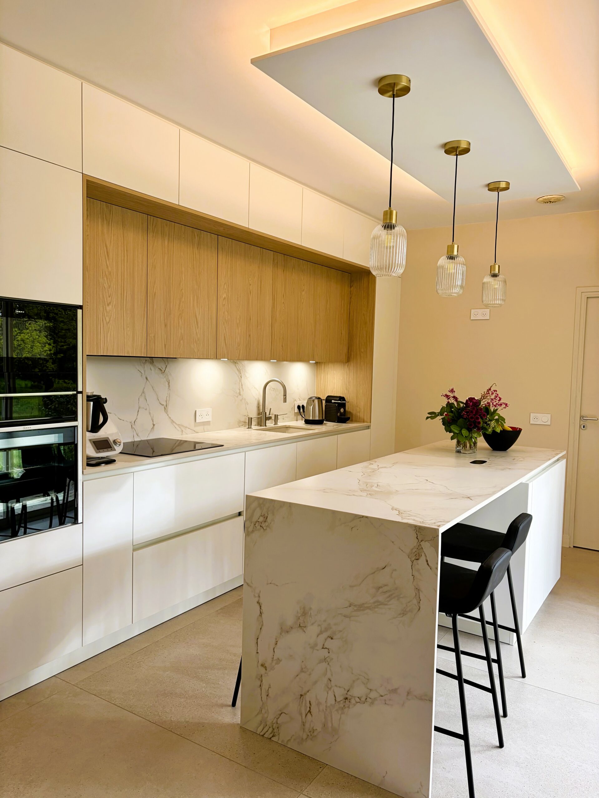 Îlot central Dekton Entzo avec retombé structurant dans une cuisine moderne ouverte à Sucé-sur-Erdre