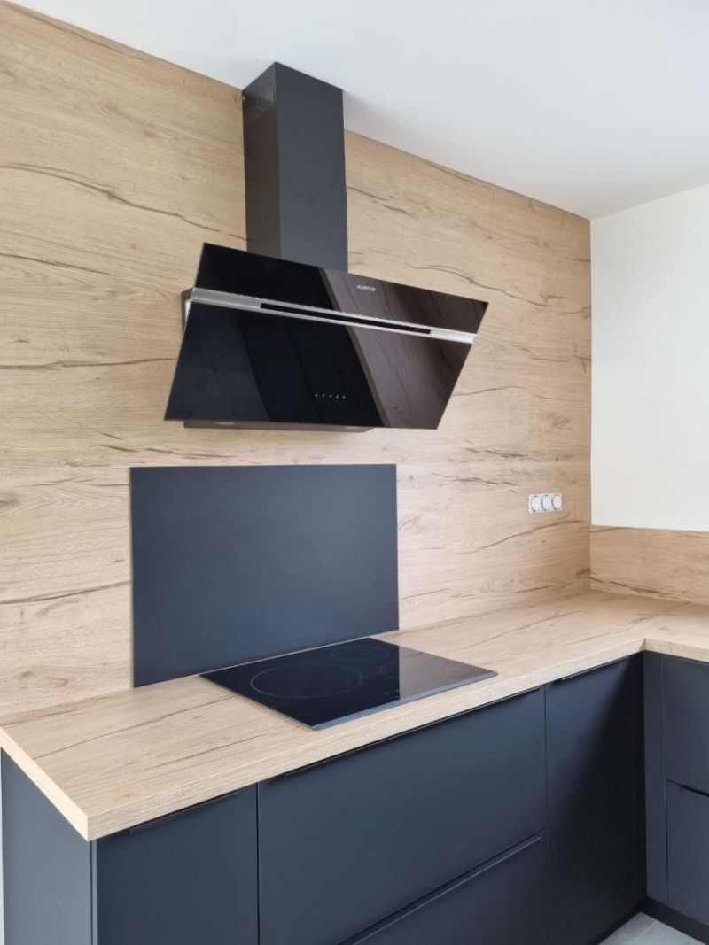 Zone de cuisson avec plaque induction encastrée et hotte design dans une cuisine à Sucé sur Erdre
