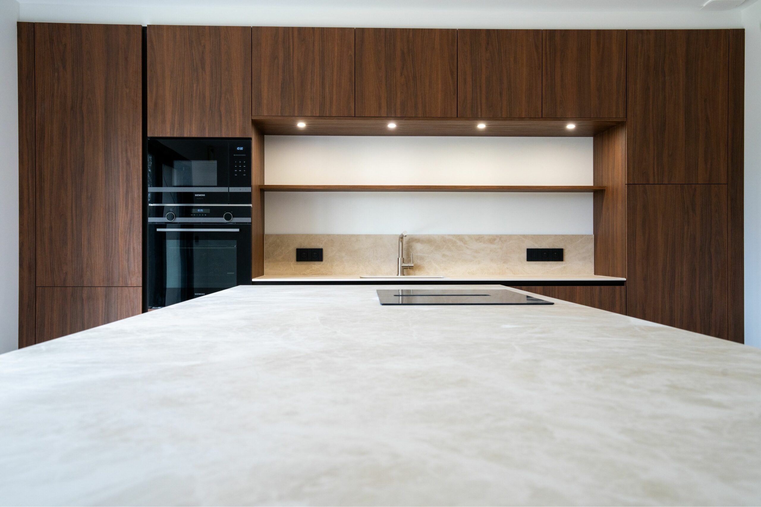 Cuisine aménagée contemporaine avec finitions bois et plan en céramique réalisée à Sucé-sur-Erdre en Loire-Atlantique