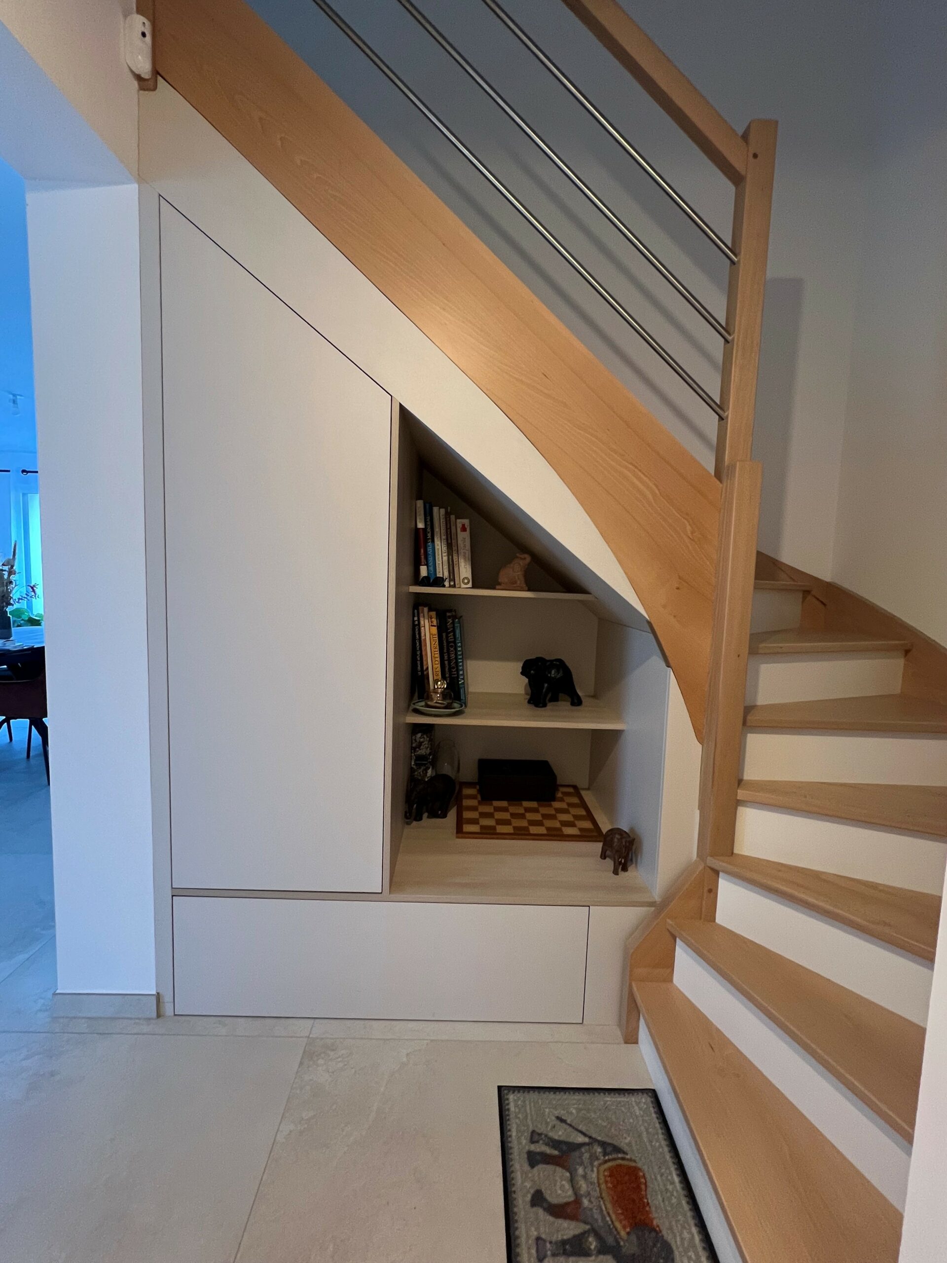 Rangement sous escalier contemporain en bois et finition beige sable conçu par Cuisines de l'Erdre près de Nantes