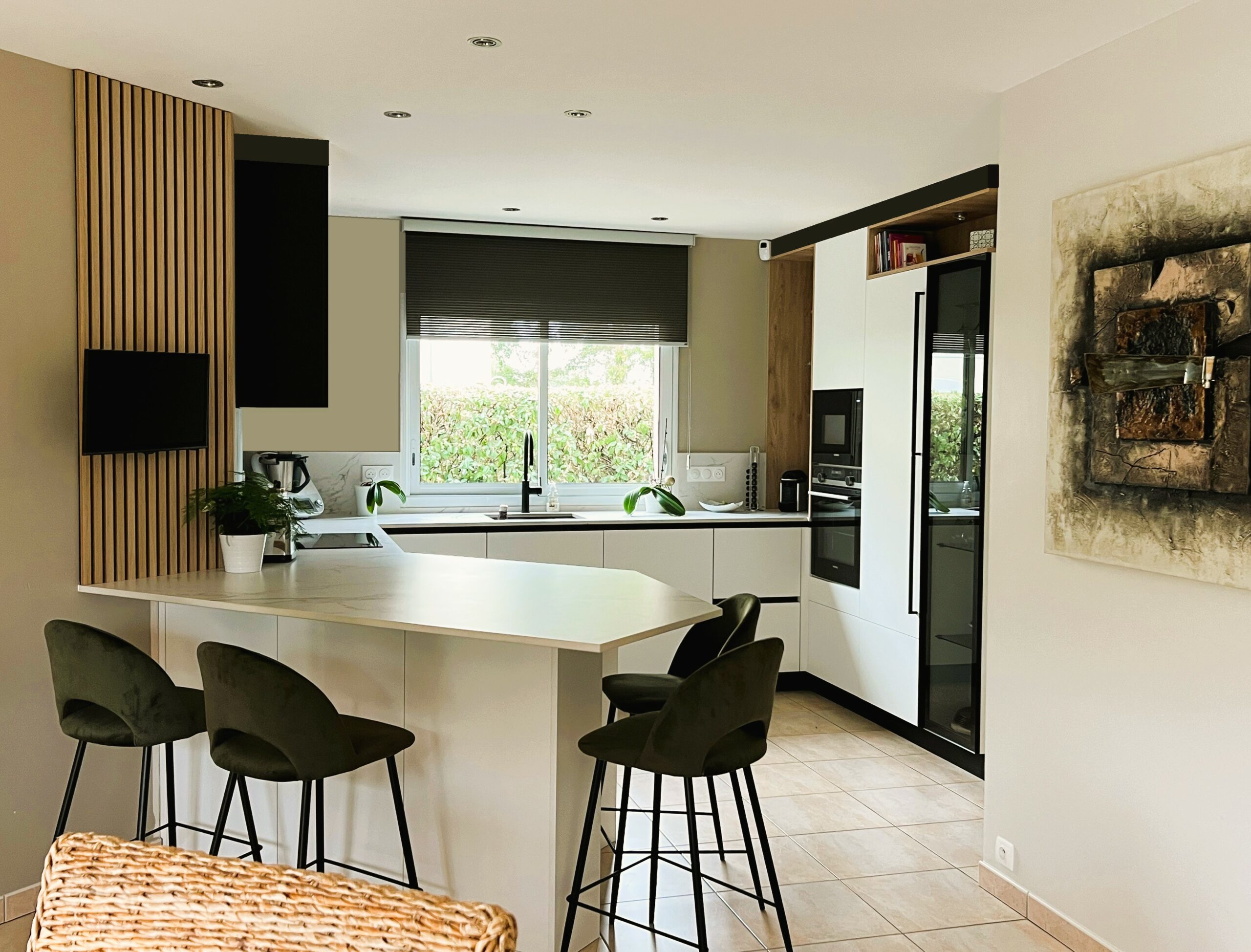 Cuisine ARMONY CUCINE sur mesure à Héric près de Nantes avec îlot central blanc, touches de bois et assises vert olive.