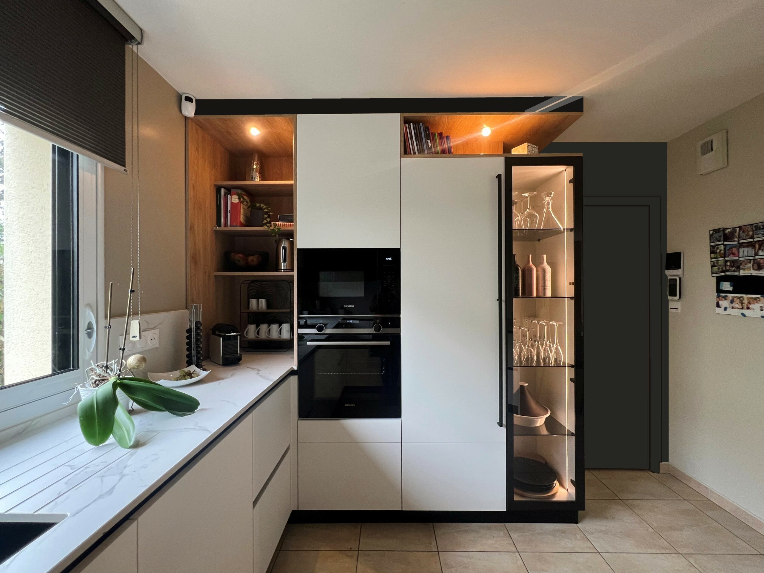 Vitrine noire vitrée avec éclairage intégré et rangements en bois dans une cuisine haut de gamme ARMONY CUCINE à Héric.